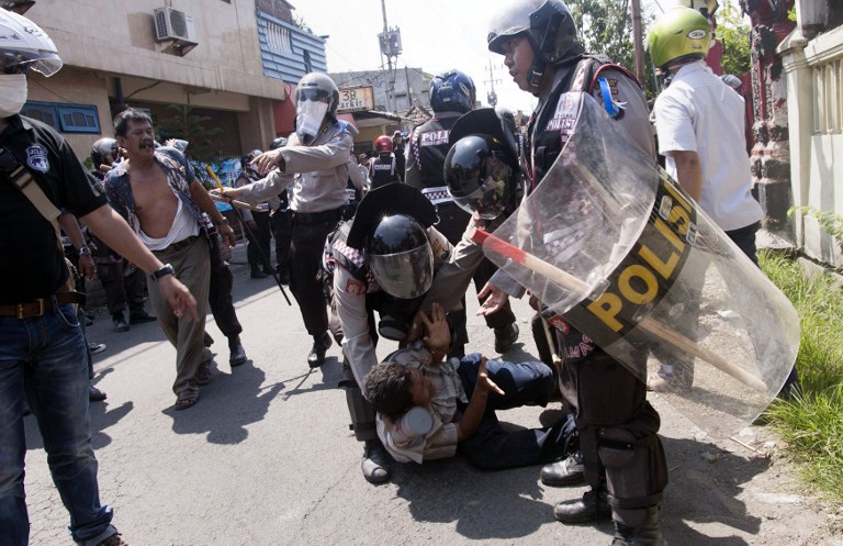 SHUTTERED. Indonesian police arrest protesters during a raid to shut down Surabaya's red light district, popularly known as "Dolly", on the eve of the Eid al-Fitr festival on July 27, 2014. Photo by Juni Kriswanto/AFP
