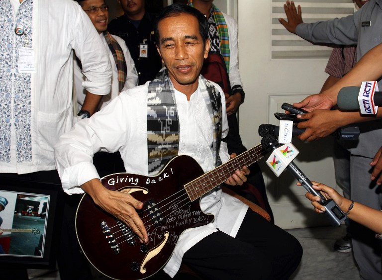 METALHEAD. Jakarta Governor Joko Widodo (C) holding a maroon bass guitar gifted to him by Robert Trujillo of US band Metallica in 2013. File photo by AFP