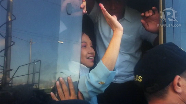 Former President Gloria Macapagal-Arroyo waves to her supporters as she leaves the Sandiganbayan after her arraignment in connection with the NBN-ZTE graft case, April 11, 2012. Photo by Paterno Esmaquel II.