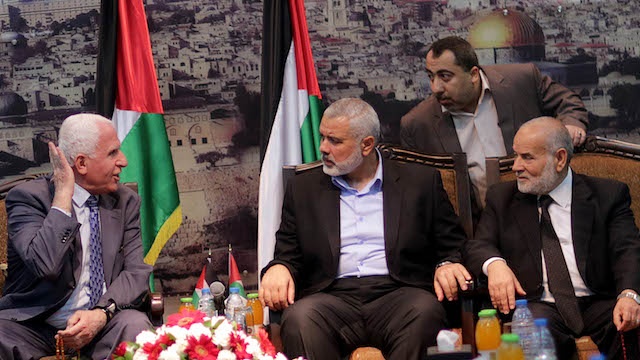 UNITY GOVERNMENT: The head of the delegation of the Palestinian Liberation Organisation (PLO) Azzam Al Ahmad (L), a senior figure in the mainstream Fatah party of President Mahmud Abbas, Hamas Prime minister Sheikh Ismael Haneiya (2-R) and senior Hamas leader Ahmad Nahar (R) sit together during a meeting in Gaza City, Gaza Strip, 22 April 2014