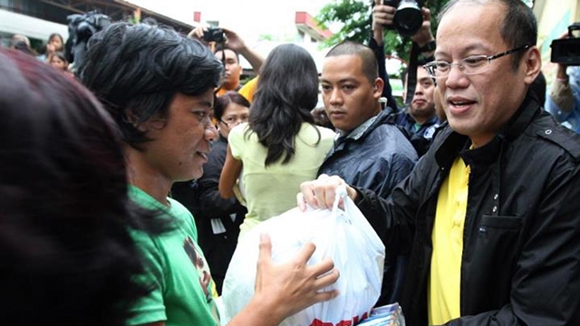 PERSONAL APPROACH. President Benigno III himself distributes relief goods in flood-stricken Muntinlupa City. Photo from Malacañang/PCOO