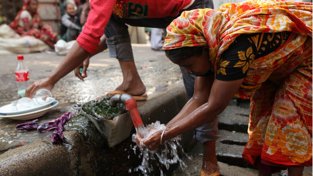 THIRST QUENCHER. A woman stops for a sip at a roadside water tap in Bangladesh. Photo credit: Abir Abdullah
