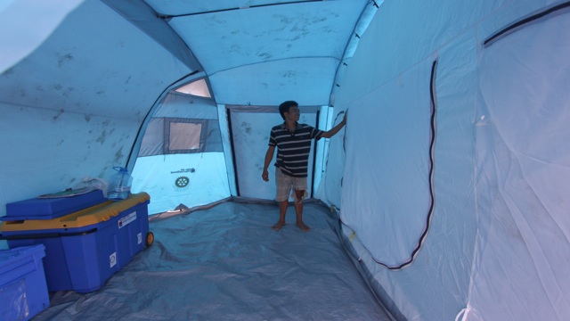 TEMPORARY HOME. 18-year-old Jason Gonzales tries to fix a temporary shelter after Pablo ripped through their home. Photo by Karlos Manlupig