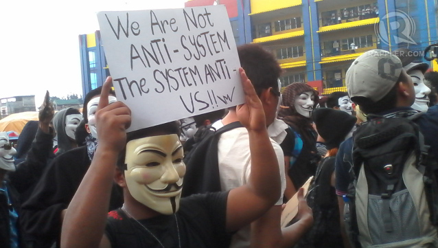 NOT ANTI-SYSTEM. A protester in Guy Fawkes mask waves a placard denouncing an oppressive system in governance. Photo by Buena Bernal/Rappler