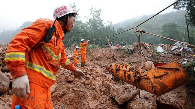Rescuers pull out the body of a victim dug out from a landslide near Dujiangyan city in Southwestern China's Sichuan province, 11 July 2013. Photo by EPA/Xiao Bo