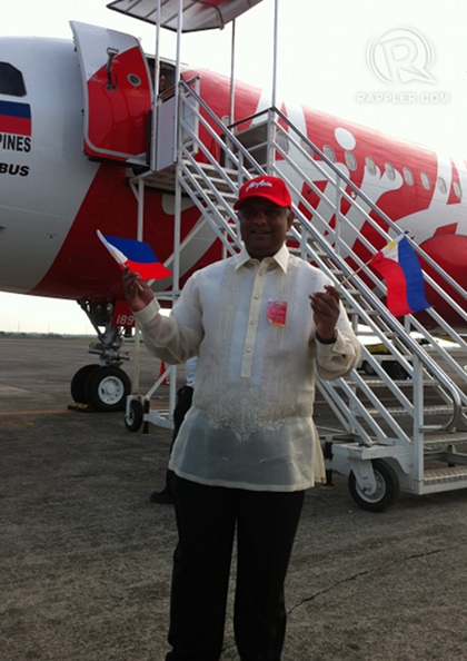 SEND OFF. AirAsia Group CEO Tony Fernandes waves Philippine flags infront of an AirAsia Philippines aircraft scheduled to fly to Kalibo, Aklan, at the tarmac of the Diosdado Macapagal International Airport, March 28, 2012. Photo by KD Suarez.