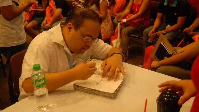 AUTHOR, IDOL. Budjette Tan of 'Trese' fame signs copies of his graphic novels. Photo courtesy of Carljoe Javier