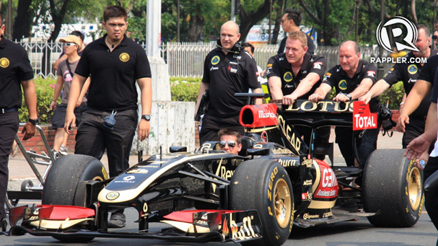 The Lotus F1 crew push the R30 racecar towards the Kilometer Zero marker for the official start of the Manila Speed Show