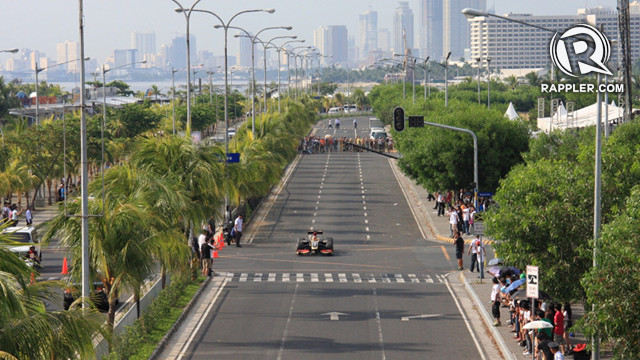 Marlon Stockinger drives the F1 car along Seaside Boulevard behind SM Mall of Asia