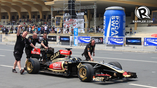 Engineers and technicians of the Lotus F1 team push the R30 back to the pit after a successful lap