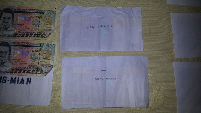 LABELLED. A barangay official surrenders envelopes containing P500 bills and labelled with names of voters to the former governor of Southern Leyte. Photo courtesy of Eva Tomol