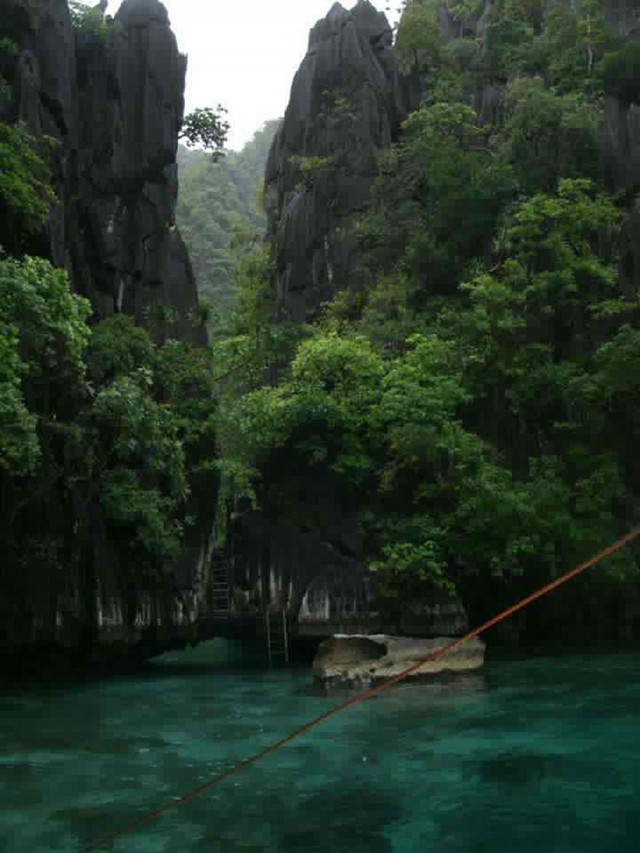 TWIN LAGOON. Under this colossal limestone wall is a small passage that serves as the entry point to the more secluded lagoon. Photo courtesy of Dos Ocampo