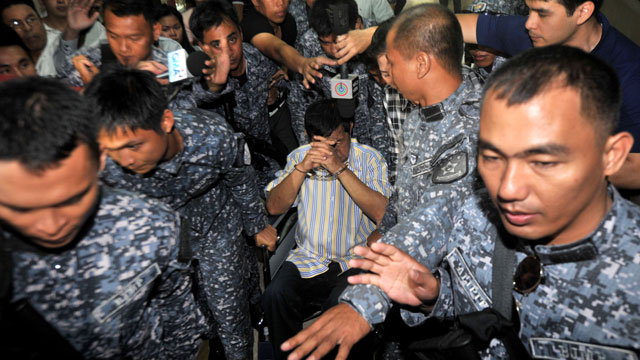 FACEDOWN. Former Maguindanao province governor Andal Ampatuan Sr. (C, in wheelchair) is guarded by jail security officers after his arraignment for electoral sabotage charges at a regional trial court of Pasay City, south of Manila, Philippines on 26 March 2012. Photo by Noel Celis/POOL/EPA