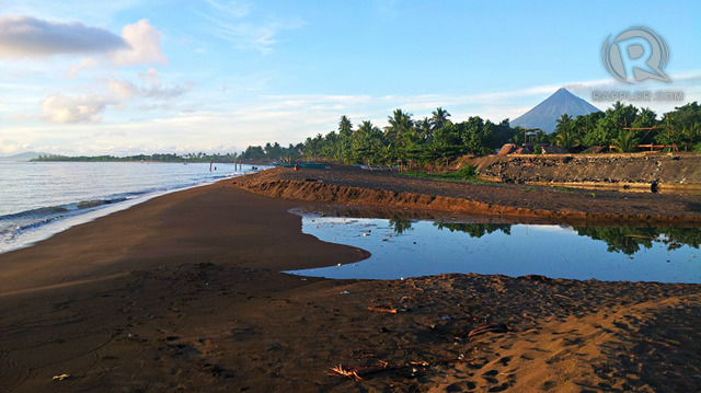 FISHING VILLAGE OF BAYBAY. A view of Baybay beach after sunrise, with the tip of Mayon Volcano in the background