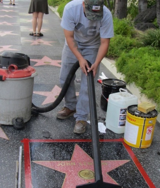 'THEY SAY IT'S YOUR BIRTHDAY.' A worker cleans up John Lennon’s star on the Hollywood Walk of Fame. Photo by Michael Thurston/AFP
