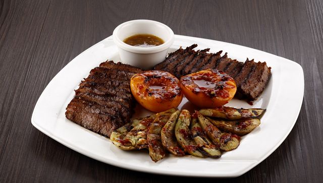 MEAT EATERS' CHOICE. Crusty Angus flank steak served with a side of grilled hoisin-glazed peaches and Chinese eggplant