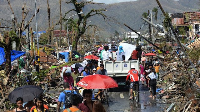 DECIMATED. Residents walk through debris and toppled power lines in Tacloban City, Leyte on November 10, 2013, three days after devastating Typhoon Yolanda (Haiyan) hit the city on November 8. AFP/Ted Aljibe