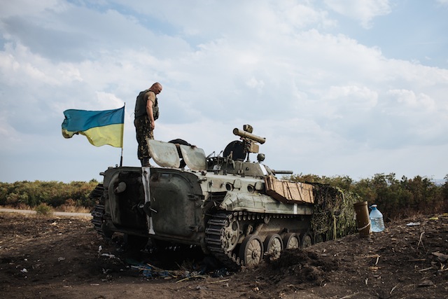 VANTAGE POINT. A Ukrainian soldier stands on an Armored Personnel Carrier (APC) close to a military camp, near the eastern Ukrainian town of Rassypnoe, 25 August 2014. Roman Pilipey/EPA