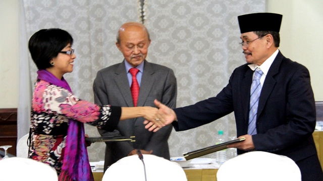 BACK ON TRACK. Gov't peace panel chair Miriam Coronel-Ferrer and MILF chief negotiator Mohagher Iqbal shake hands as Malaysian facilitator Tengku Dato' AB Ghafar Tengku Mohamed looks on during the 36th round of formal talks. Photo by OPAPP