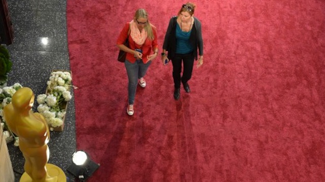 Women walk ot the red carpet in front of the Dolby Theatre in preparation one day before the 85th Academy Awards on February 23, 2013 in Hollywood, California. AFP PHOTO / JOE KLAMAR 