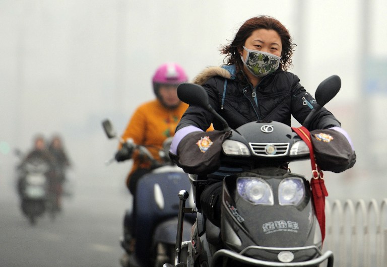 DRASTIC CHANGE NEEDED. A Chinese motorist wears a mask as she makes her way along a smog filled road in Hefei, east China's Anhui province on November 29, 2011. The amount of global warming gases sent into the atmosphere made an unprecedented jump in 2010, according to the US Department of Energy's latest world data on carbon dioxide emissions, with China alone was the biggest polluter with a spike of 212 million metric tons in 2010 over 2009. AFP PHOTO