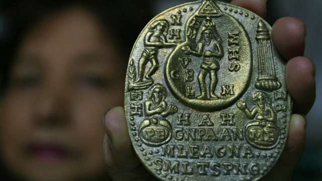 PERVASIVE. Amulet and talisman vendor Sally Sibal, 62, holds an amulet of the "Infinite God" in her shop in Manila, Philippines, 06 July 2003. File photo by Mike Alquinto/EPA