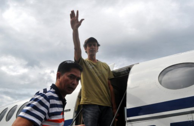 BOARDING. Jordanian TV journalist Bakr Atyani waves as he boards a plane at the airport in Jolo, Mindanao on December 6, 2013, on his way to Manila, a day after he was discovered on a jungle road. AFP PHOTO