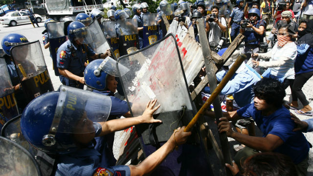 VIOLENCE BREAKS. Residents and anti-riot police clash as the latter destroy the barricade by the residents during a demolition on shanties along Agham Road in Quezon City. Photo by Ed Alba.