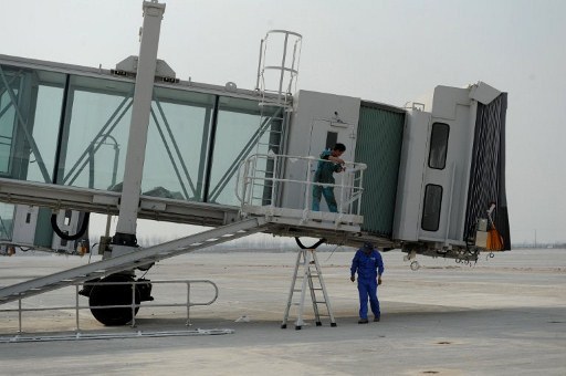 EXPANSION. Chinese workers check the aerobridges as construction is underway at the new Hefei Xinqiao airport and its four runways, in Hefei, east China's Anhui province on March 14, 2012. 