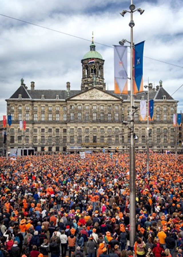 ORANGE COUNTRY. People, most of them wearing orange tee shirts, hats or plastic crowns, gather on April 30, 2013 at the Dam Square in Amsterdam, The Netherlands, to attend the investiture of the country's new King. Photo by AFP