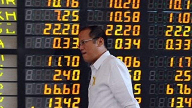 SOARING INDEX. President Benigno Aquino says he's the main salesman of the Philippines. In this file AFP photo, he walks past an electronic display when he led the March 6, 2012 ceremony marking the 5,000 record-high