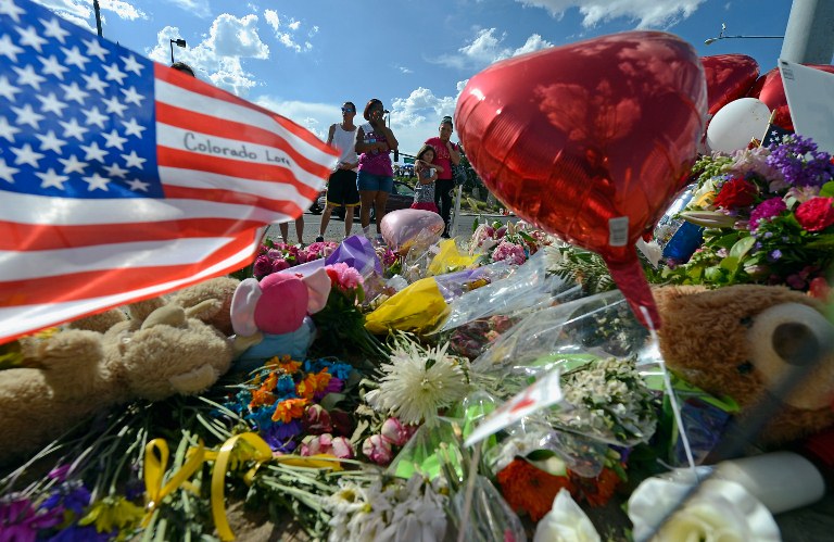 Tiffany Garcia (R) and her six-year-old daughter, Angelina Garcia, cry as they look at a makeshift memorial across the street from the Century 16 movie theater the day after a gunman killed 12 people and injured 59 during an early morning screening of 'The Dark Knight Rises,' July 21, 2012 in Aurora, Colorado. Police in Aurora, a suburb of Denver, say they have the suspect James Holmes, 24, in custody. Kevork Djansezian/Getty Images/AFP