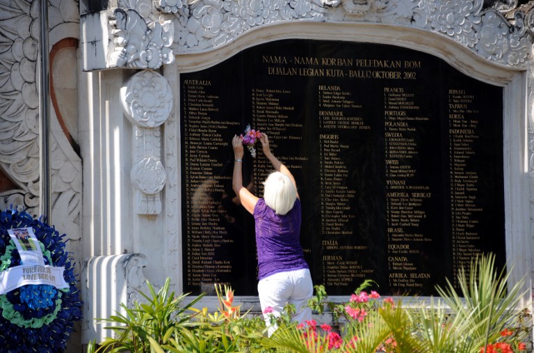 BALI, 10 YEARS ON. A foreign tourist places flowers on the plaque of a memorial monument for the 2002 Bali bombing victims built next to the site of the blasts, as Bali prepares to mark the 10th anniversary of the attack in the Kuta tourist area near Denpasar on the Indonesian resort island of Bali on October 10, 2012. The 2002 blast, blamed on the militant Jemaah Islamiyah network linked to Al-Qaeda, tore apart a busy nightclub strip on the resort island of Bali killing 202 people, including 88 Australians. AFP PHOTO / SONNY TUMBELAKA