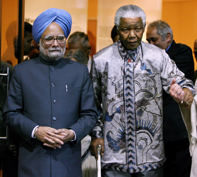 'TRUE GANDHIAN.' Former South African President Nelson Mandela walks with visiting Indian Prime Minister Manmohan Singh in Johannesburg, South Africa, 02 October 2006. File photo by Jon Hrusa/EPA