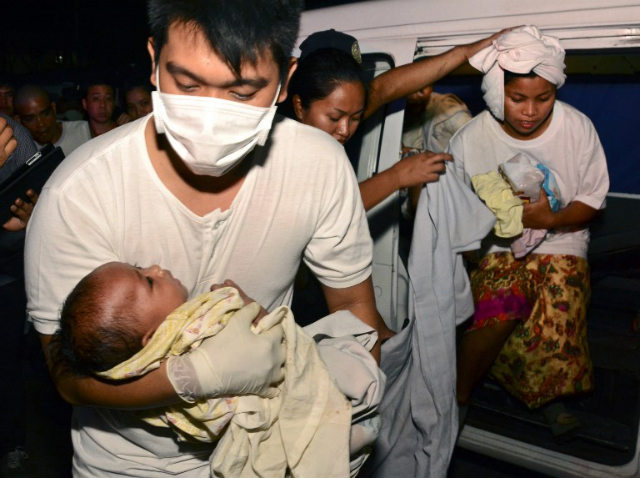 SEARCH ON. Three-month old Trisia Mae Kumaro is among those rescued from a sea collision in Cebu. Rescuers are still looking for more than 200 missing. Photo by AFP