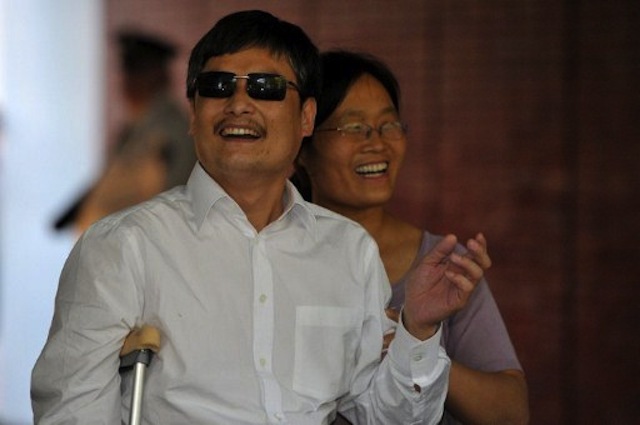 Blind Chinese activist Chen Guangcheng (L) and his wife Yuan Weijing smile upon their arrival at the New York University Village appartment complex in Manhattan in New York, May 19, 2012. AFP PHOTO / MLADEN ANTONOV