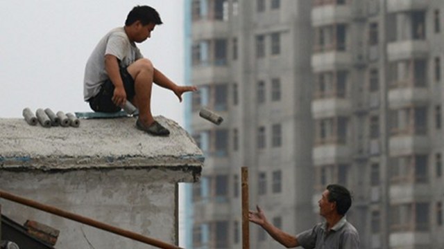 DROP. The world's second largest economy grew 7.7% in 2012, not 7.8%. AFP file photo shows two Chinese workers work on the roof of a building at a construction site in Beijing