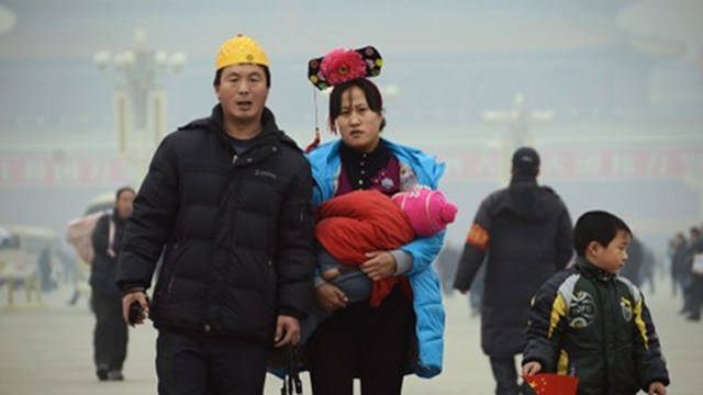 GROWTH. A couple wearing Qing dynasty style headwear walk with their children in Tiananmen square in Beijing in December, 2012. China announces a 7.8% economic growth for the full year, the second annual slowdown amid challenges. AFP photo