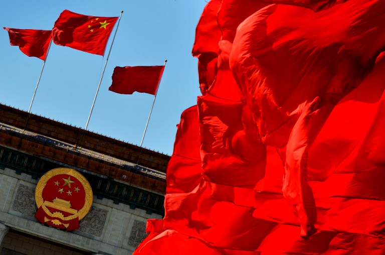 Chinese flags fly over the Great Hall of the People which is the site of the Communist Party Congress in Beijing on November 13, 2012. AFP PHOTO/Mark RALSTON