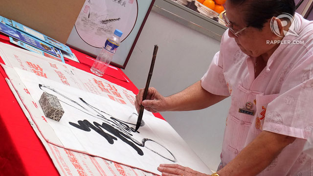 CHINESE CALLIGRAPHY. A demonstration of intricate Chinese calligraphy enthralls passers-by in the atrium of Lucky Chinatown Mall