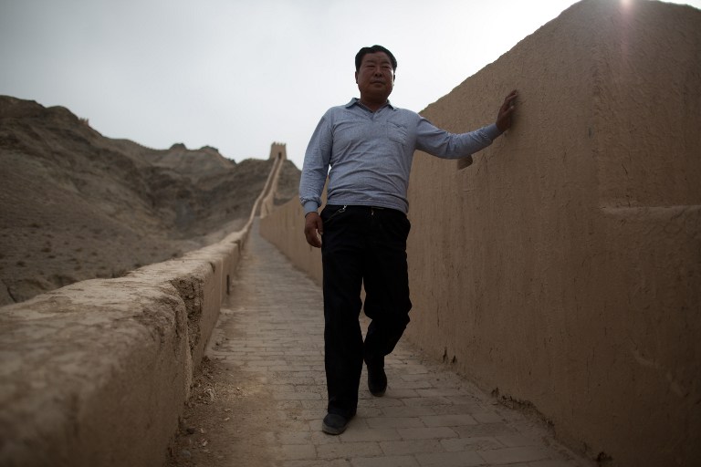 Yang Yongfu stands on a section of the Great Wall that he restored himself. AFP photo