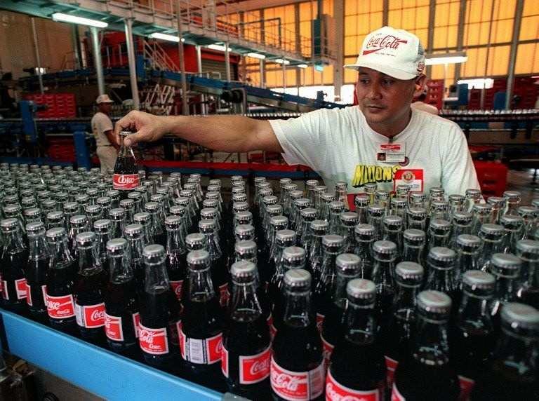 CHANGING HANDS. The transfer of control of the Philippine bottler to the Mexican firm Coca-Cola FEMSA is the latest in the long series of ownership changes in Coca-Cola Philippines. Photo by AFP