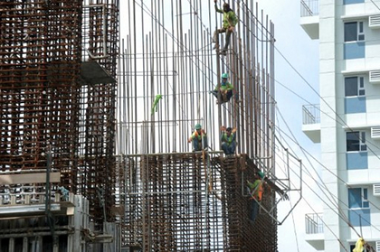 BOOM. Construction workers harnessed to steel bars at a high-rise building construction site in Manila. Photo by AFP