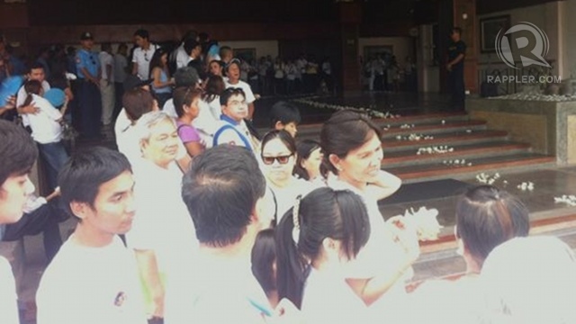 Friends, relatives await Dolphy's coffin on the path to his burial site with flowers at hand. Photo by Natashya Gutierrez