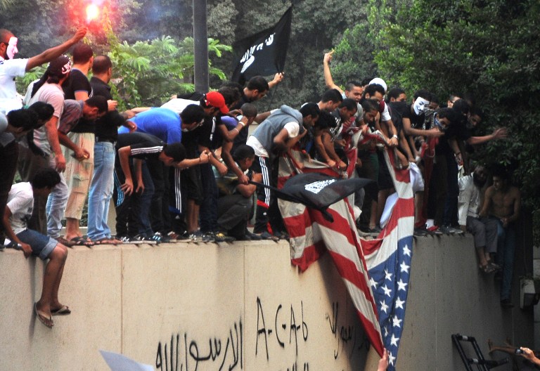 Egyptian protesters tear down the US flag at the US embassy in Cairo on September 11, 2012 during a demonstration against a film deemed offensive to Islam. AFP PHOTO