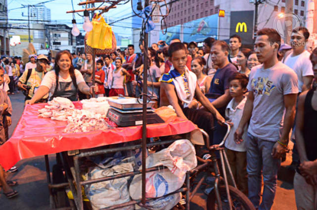 CHANGES. Onlookers watch on as Divisoria hawkers move their stalls around in preparation for the night market.