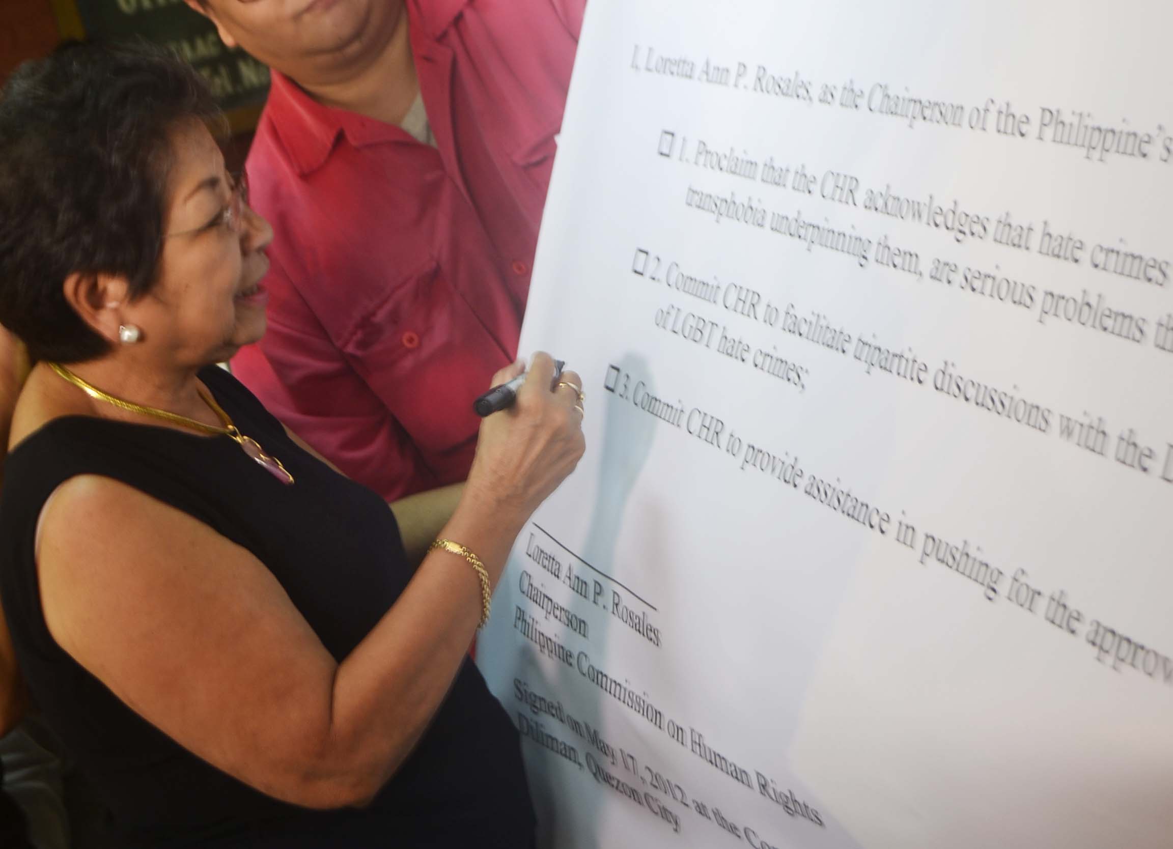 LEADER. Loretta Ann P. Rosales signs a "certificate" of appreciation for all her contributions to the LGBT movement. Photo by Dawn Fabrero
