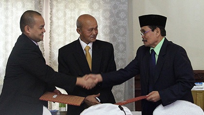 Marvic Leonen (L), chair of the Philippine government panel, and Mohagher Iqbal (R), chief negotiator of the Moro Islamic Liberation Front (MILF), shake hands at the end of the 31st round of Formal Exploratory Talks in Kuala Lumpur, Malaysia, September 8, 2012. Looking on is Malaysian facilitator Tengku Dato Abdul Ghafar Tengku Mohamed (C). Photo courtesy of the OPAPP