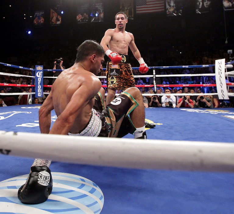 HUGE UPSET. Danny Garcia (top) from Philadelphia, Pennsylvania, stands over Amir Khan, from Bolton, England after knocking him down to the canvas in the fourth round on July 14, 2012 at the Mandalay Bay Events Center in Las Vegas, Nevada. Photo from AFP.