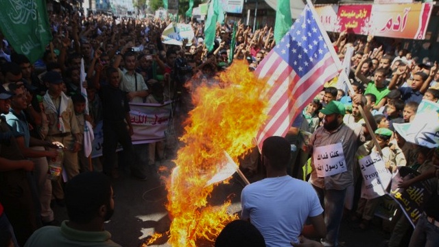 WEEK OF VIOLENCE. Palestinian men burn the US flag during a protest against a film mocking Islam, in Rafah, southern Gaza Strip, on September 14, 2012. Palestinians protested an anti-Muslim film, with thousands gathering in the Gaza Strip and hundreds in Jerusalem where there were clashes with Israeli police. AFP photo/Said Khatib 